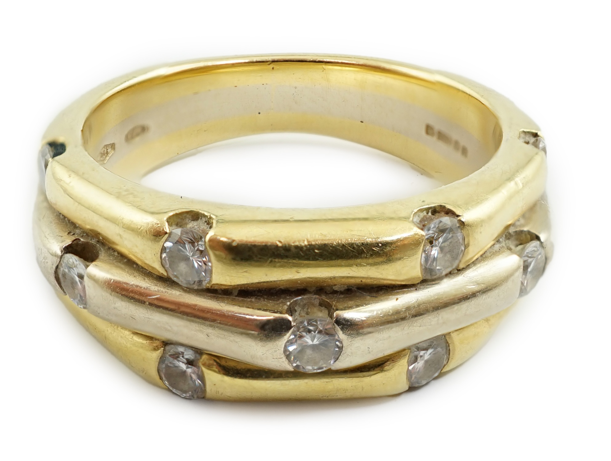 A modern two colour 18ct gold eleven stone diamond set triple shank ring